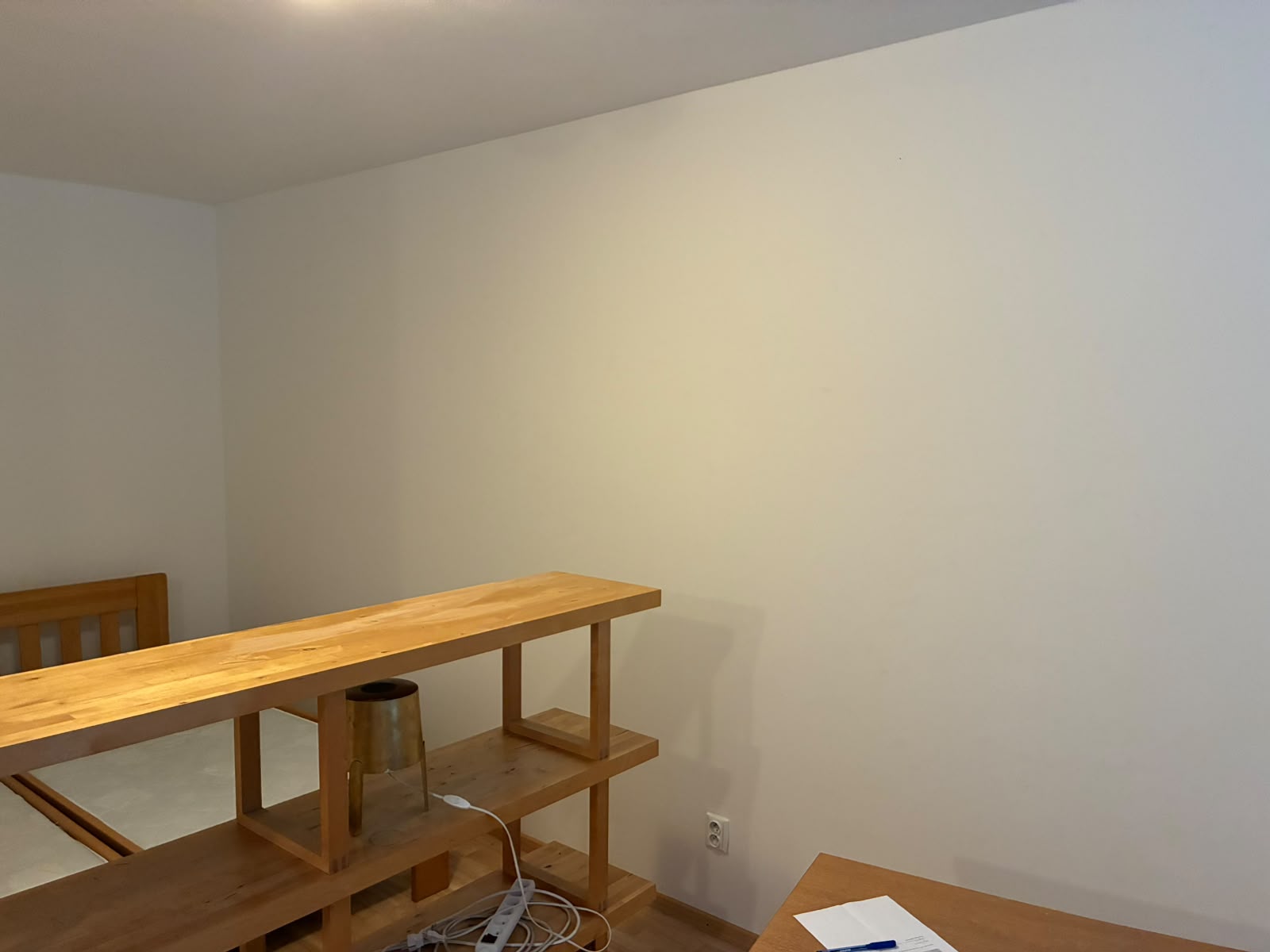Hotová bílá stěna pokoje po vymalování a přebroušení